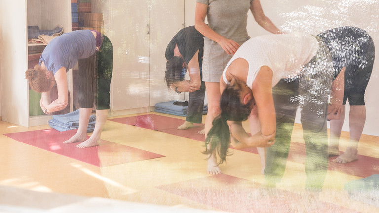 Yoga-Lehrerin leitet Gruppe zu Übungen an
