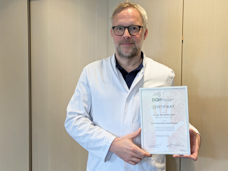 Dr. med. Michael Berndsen hält das Zertifikat in den Händen