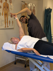 Physiotherapeut überprüft die Beweglichkeit des Arms der Patientin Physiotherapeut überprüft die Beweglichkeit des Arms der Patientin