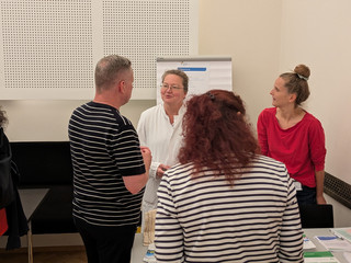 Dr. med. Katja Warnecke im Gespräch mit drei Personen am stand der Rheuma-Liga