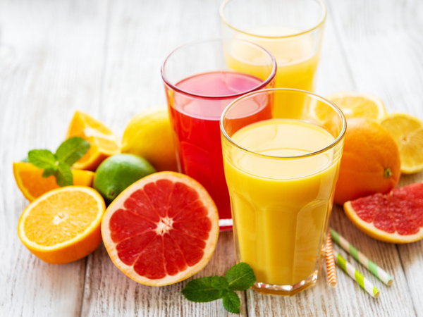 Zitrusfrüchte und Gläser gefüllt mit Saft