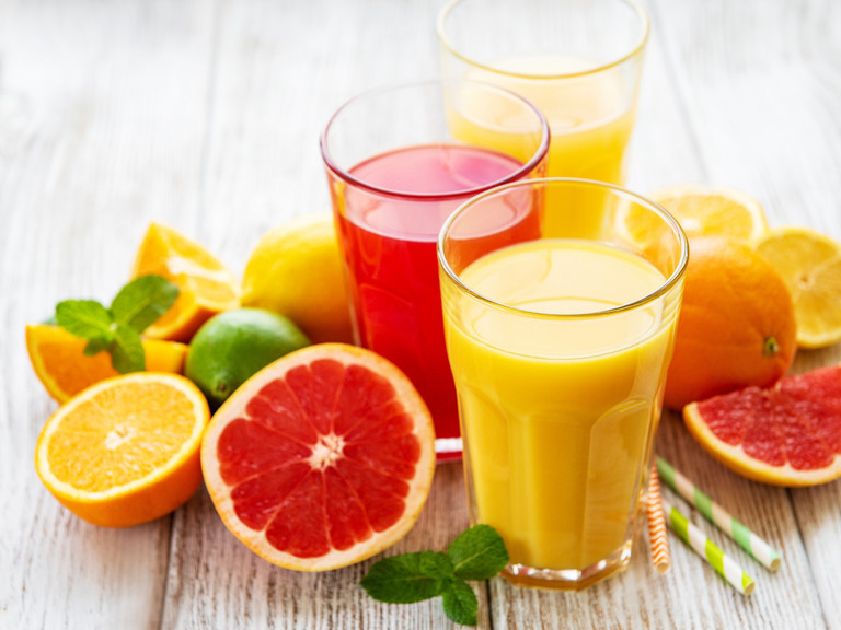 Zitrusfrüchte und Gläser gefüllt mit Saft