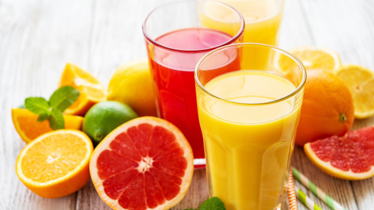 Zitrusfrüchte und Gläser gefüllt mit Saft