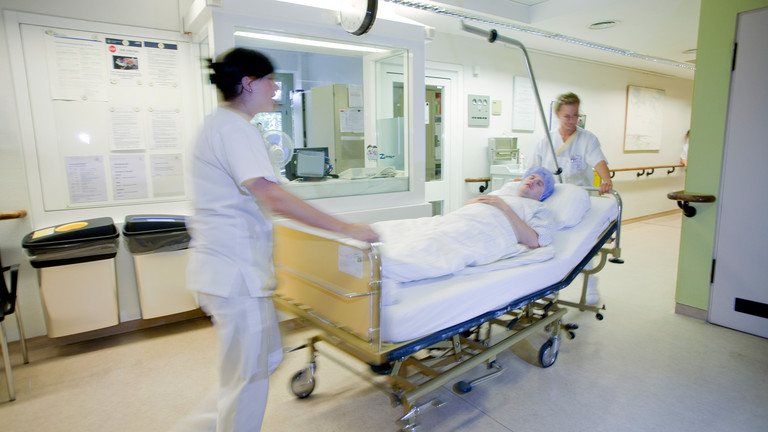 Pflegekräfte schieben Bett mit einem Patienten - Immanuel Krankenhaus Berlin - Obere Extremität, Hand- und Mikrochirurgie 
