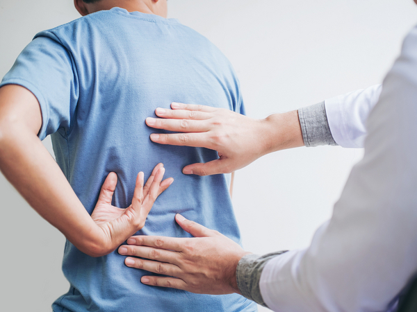 Arzt untersucht Patient mit Rückenbeschwerden