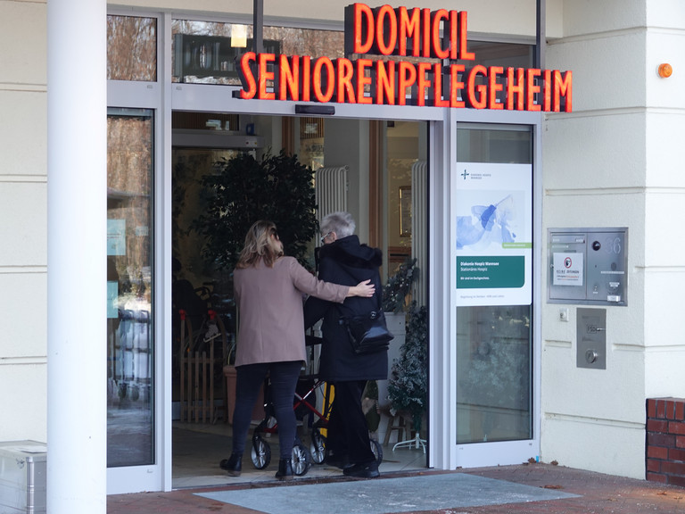 Mandy Schneider aus der Hospizverwaltung begleitet eine Gästin zu Fuß zurück in das Gebäude