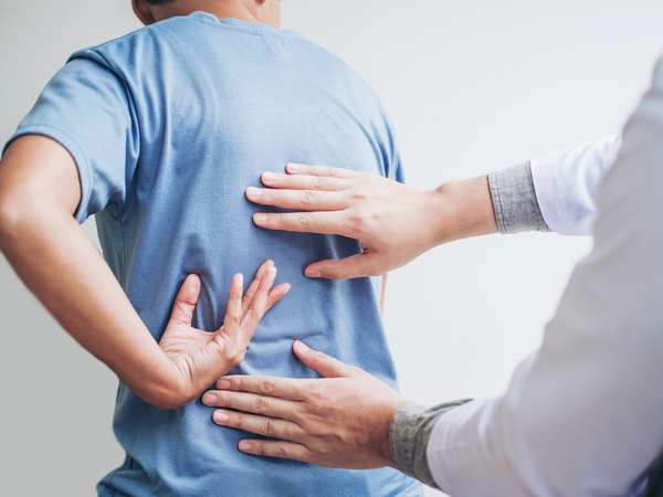 Arzt untersucht Patient mit Rückenbeschwerden